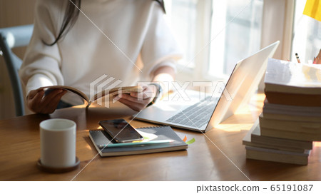 Cropped shot of Asian girl reading a book to Cropped shot of Asian girl reading a book to 65191087