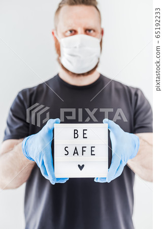 Man holding lightbox with text Be safe in his hand Man holding lightbox with text Be safe in his hand 65192233