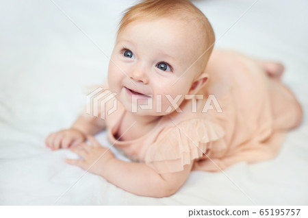 Portrait of a sweet infant smile wearing a pink dress in studio 65195757
