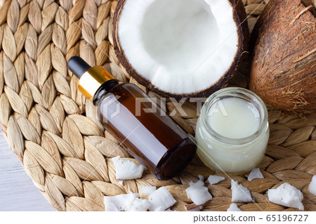 Coconut oil and fresh coconuts on the wooden table 65196727