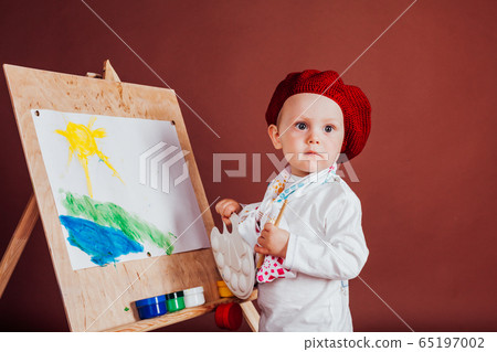 little boy artist brush and paints paints a picture 65197002