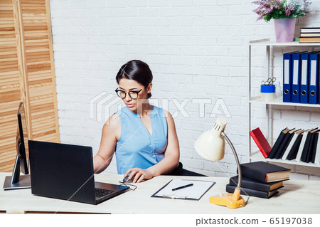 business girl sits at a computer in the Office paper folders business girl sits at a computer in the Office paper folders 65197038