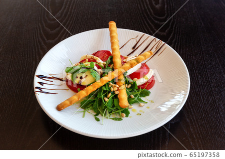 Caprese salad with buffalo mozzarella. Dark background. Close-up. Caprese salad with buffalo mozzarella. Dark background. Close-up. 65197358