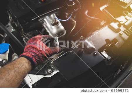 Mechanic man is opening radiator cap. Mechanic man is opening radiator cap. 65199571