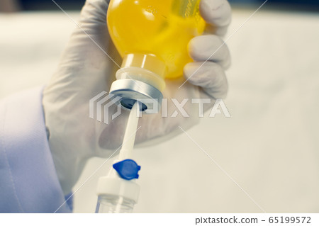 Hand inject I.V. drip set into normal saline solution. Hand inject I.V. drip set into normal saline solution. 65199572