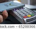 NFC - Near field communication, mobile payment. Bank terminal for non-cash payment by mobile phone or credit card. The buyer applies the phone, makes a purchase on the Internet 65200366