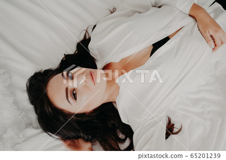 girl in lingerie lying on a bed with a rose girl in lingerie lying on a bed with a rose 65201239