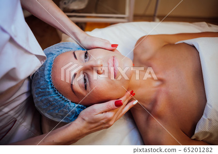 doctor cosmetologist doing facial massage girl Spa doctor cosmetologist doing facial massage girl Spa 65201282
