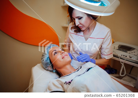 doctor beautician increases lip patient an injection syringe doctor beautician increases lip patient an injection syringe 65201308
