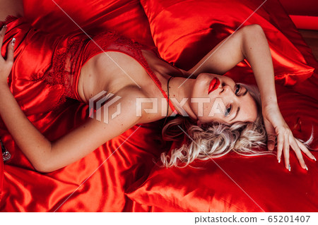 sexy blonde in red underwear lies on a bed 65201407