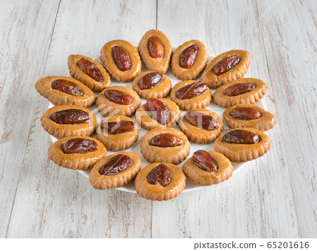 Homemade Eid Dates sweets on a white wooden table Homemade Eid Dates sweets on a white wooden table 65201616