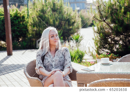 blonde girl sitting at the beach restaurant coffee blonde girl sitting at the beach restaurant coffee 65201638