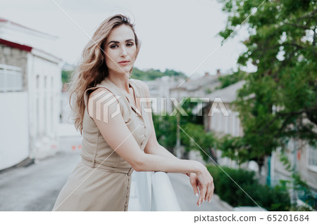 Portrait of a beautiful fashionable woman in a stylish beige dress 65201684