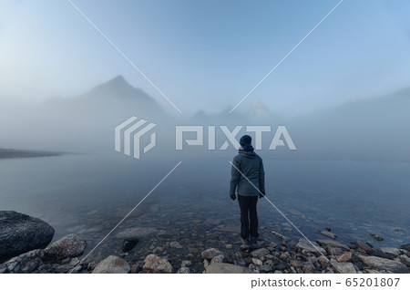 Man traveler standing on Lake Magog with Mount 65201807