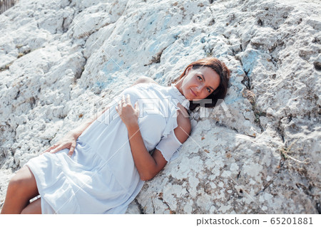 Beautiful woman with long hair in dress on cliff landscape in a journey Beautiful woman with long hair in dress on cliff landscape in a journey 65201881