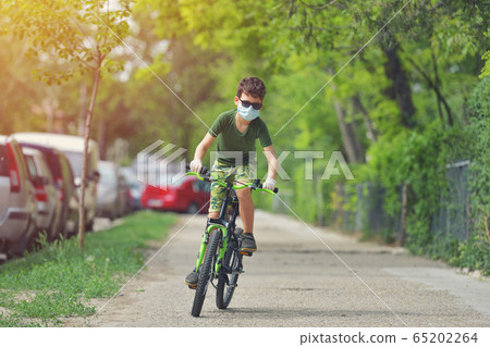 Happy kid having fun near home with a bicycle on Happy kid having fun near home with a bicycle on 65202264