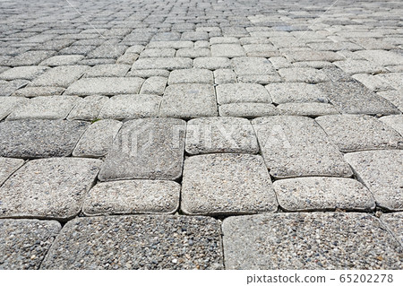 Road paved with gray square road tiles Road paved with gray square road tiles 65202278