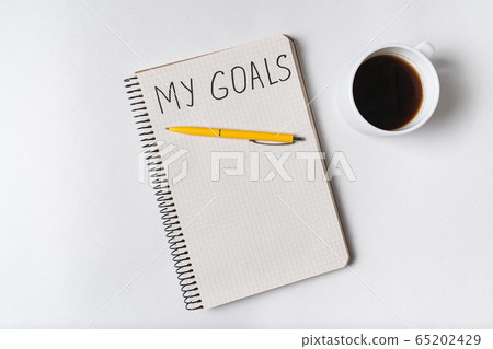 Inscription in copybook MY GOALS. Cup of coffee Inscription in copybook MY GOALS. Cup of coffee 65202429