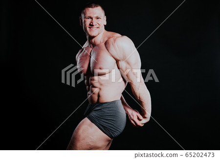 the athlete bodybuilder shows his muscles after sports 65202473
