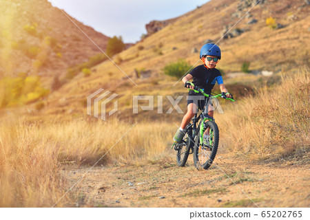 Happy kid boy of 7 years having fun in autumn park Happy kid boy of 7 years having fun in autumn park 65202765