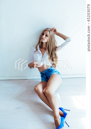 beautiful blonde girl with blue eyes sitting on the floor in a white room 1 beautiful blonde girl with blue eyes sitting on the floor in a white room 1 65203079