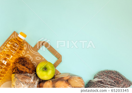Food for quarantine isolation period flat lay on light blue background with copy space. Cooking oil, pasta, water and beans. Crisis food supplies. Delivery, donation concept. 65203345