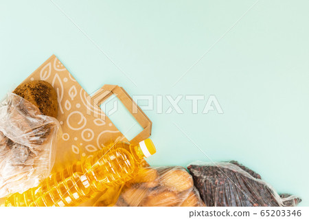 Food for quarantine isolation period flat lay on light blue background with copy space. Cooking oil, pasta, water and beans. Crisis food supplies. Delivery, donation concept. 65203346