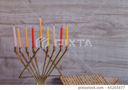 Extinguished Hanukkah candles and smoke. Stack of molten wax in cups with menorah Extinguished Hanukkah candles and smoke. Stack of molten wax in cups with menorah 65203877