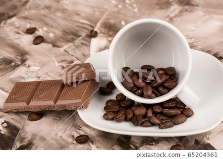 Close up. Coffee beans in a coffee cup and saucer. Close up. Coffee beans in a coffee cup and saucer. 65204361