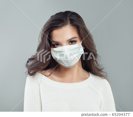 Portrait of young woman in protective mask 65204377