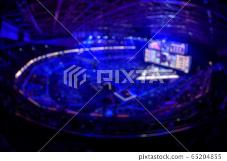 Blurred background of an esports event - Main stage venue, big screen and lights before the start of the tournament. Blurred background of an esports event - Main stage venue, big screen and lights before the start of the tournament. 65204855