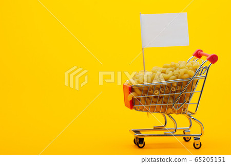 The grocery cart is filled with pasta on a bright 65205151