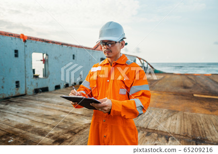 Filipino deck Officer on deck of offshore vessel or ship fills checklist. Paperwork at sea 65209216