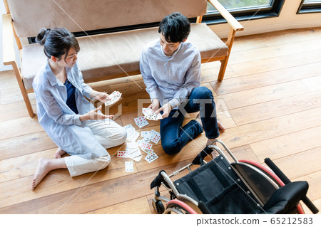 Couple enjoying wheelchair playing cards Couple enjoying wheelchair playing cards 65212583