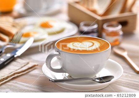 Cup of coffee latte with breakfast on wooden table Cup of coffee latte with breakfast on wooden table 65212809