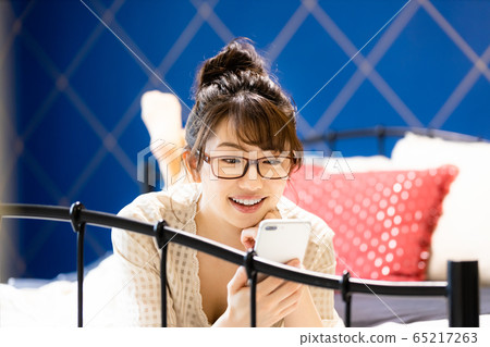 女臥室床智能手機房間穿微笑 女臥室床智能手機房間穿微笑 65217263