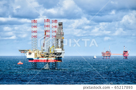 Oil rigs and supply vessels at sea 65217893