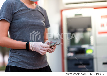 Woman counting money wearing protective gloves Woman counting money wearing protective gloves 65219337