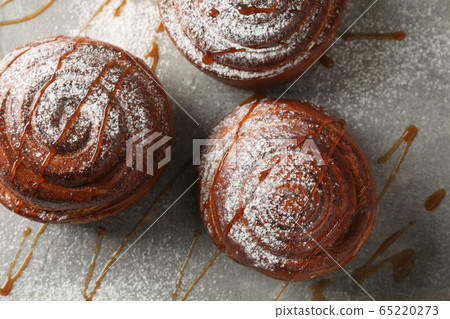 Cinnamon rolls with caramel and powdered sugar on 65220273