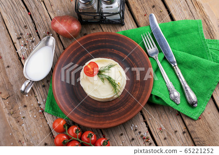 Mashed potatoes in plate on wooden table Mashed potatoes in plate on wooden table 65221252