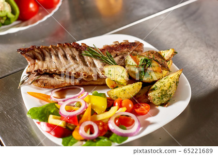 the chef prepares in the restaurant. Grilled rack of lamb with fried potatoes and fresh vegetables the chef prepares in the restaurant. Grilled rack of lamb with fried potatoes and fresh vegetables 65221689
