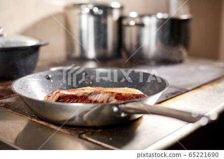fried ribs of lamb. Cooking with fire in frying pan. Professional chef in a kitchen of restaurant cooking. Man frying food in flaming pan on hob. fried ribs of lamb. Cooking with fire in frying pan. Professional chef in a kitchen of restaurant cooking. Man frying food in flaming pan on hob. 65221690