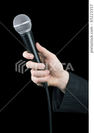 Close up of man's hand holding microphone isolated 65223357