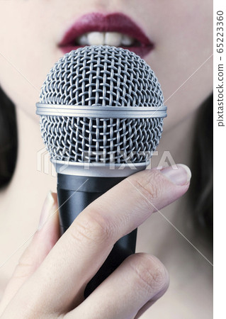 Close up of a young woman with red lips holding 65223360