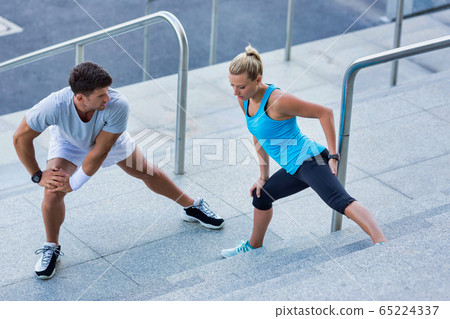 Young attractive couple exercising in stairs 65224337