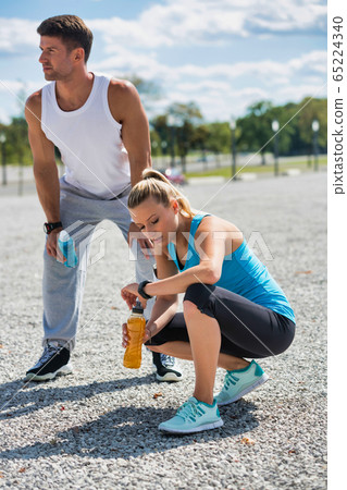 Young couple drinking energy drinks while resting Young couple drinking energy drinks while resting 65224340