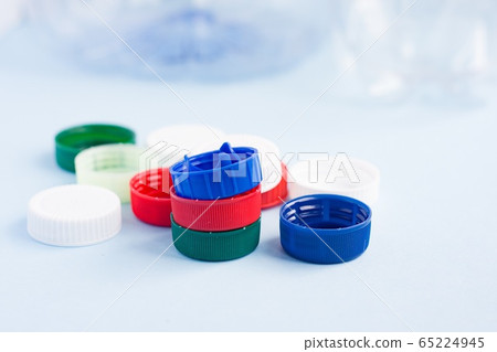 Colorful plastic caps against bottles. Plastic gabarge 65224945