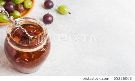 Gooseberry jam in a jar with fresh gooseberry 65226068