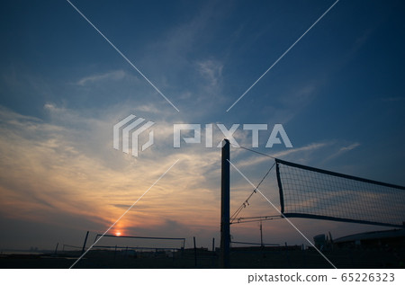 Beach volleyball net and sunset sky at sunset 65226323