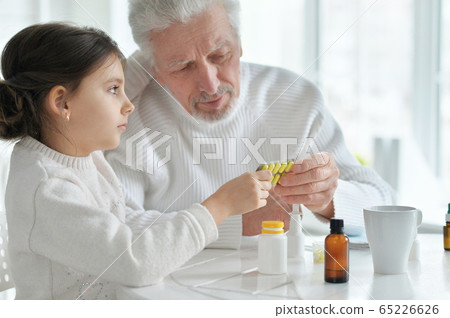 Sick granddaughter with grandfather sitting at home Sick granddaughter with grandfather sitting at home 65226626
